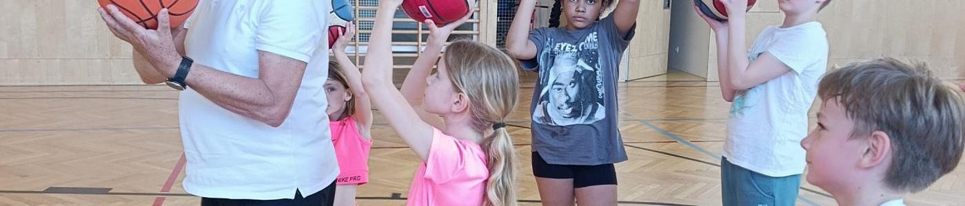 Kinder und Lehrer mit Basketbällen
