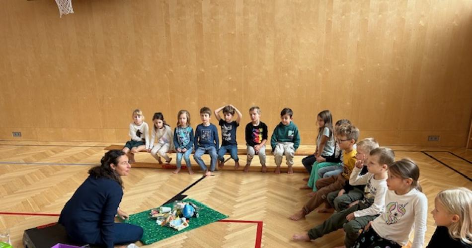Frau Susanne zeit den Kindern den Abfall