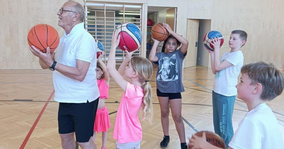 Kinder und Lehrer mit Basketbällen