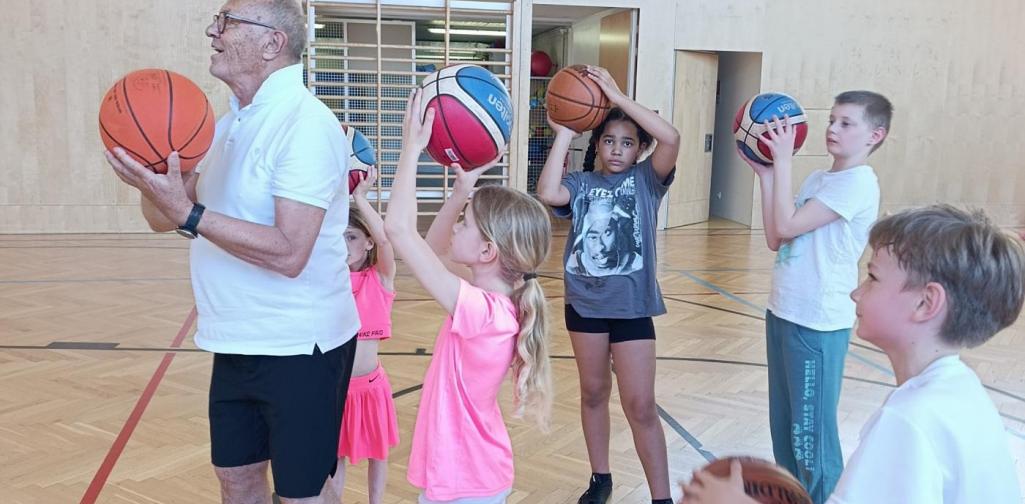Kinder und Lehrer mit Basketbällen